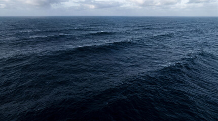 Fototapeta premium Massive Ocean Swells Rolling Across Deep Dark Indigo Sea High Seas Storm Navigation Theme Backdrop