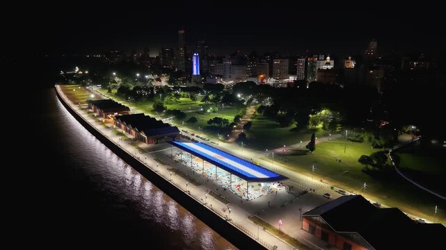 Vista nocturna de la Costanera, r&iacute;o Paran&aacute;, Monumento Hist&oacute;rico Nacional a la Bandera y ciudad de Rosario iluminada. Skyline urbano, Santa Fe, Argentina. Turismo, arquitectura, patrimonio, viaje, luce