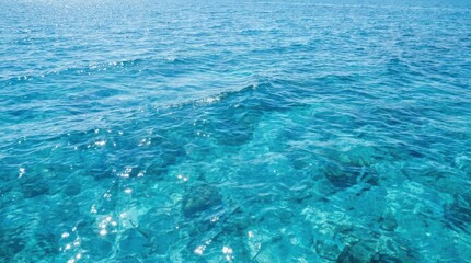 Obraz premium Crystal Clear Turquoise Tropical Ocean Water Surface with Visible Coral Reef Seabed Below Perfect for Summer Vacation Backgrounds and Travel Concept Imagery