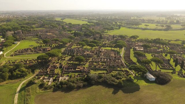 Aerial view of the ancient ruins of Pompeii with stone walls and pine trees under soft sunlight in Pompeii, Italy.