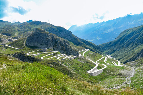 Aerial view of the winding Tremola road at Passo del San Gottardo, featuring sharp hairpin turns through the rugged alpine landscape of Airolo, Ticino, Switzerland.