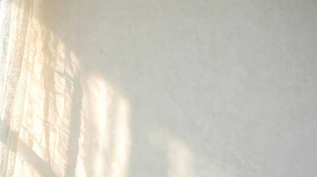 Sunlight from a window is casting abstract shadows from a sheer curtain onto a white textured wall, creating a peaceful and soft domestic atmosphere