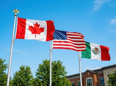 Flags of canada, the united states, and mexico flying together on flagpoles against a clear blue sky, representing north american cooperation