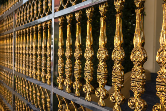 Golden ornate metal fence details creating luxury pattern