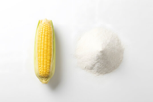 Fresh ear of yellow corn with mound of white cornstarch powder