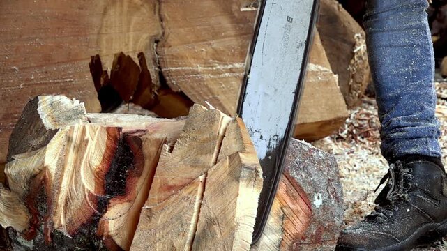 Close up of chainsaw cutting firewood log into smaller pieces, showcasing timber processing, woodworking and manual labor in Mexico