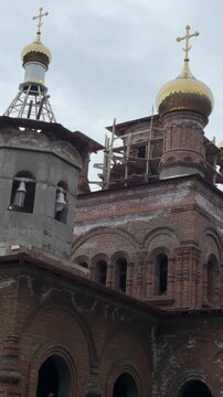 A new Orthodox church with golden domes and a bell tower is under construction in Chemal, Republic of Altai