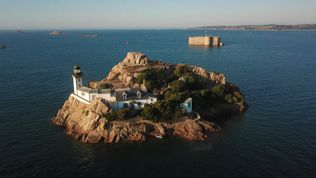 Aerial view of the historic Ile Louet lighthouse and its keeper's house situated on a rocky island in the Baie de Morlaix, Carantec, Brittany, France.