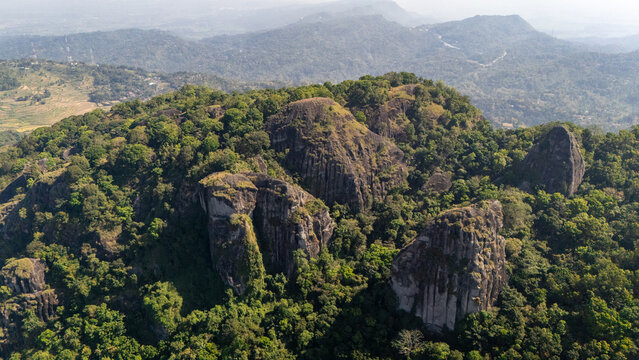 Aerial view of Ancient Volcano Nglanggeran featuring massive rock formations surrounded by dense tropical forest in Kecamatan Patuk, Daerah Istimewa Yogya, Indonesia.