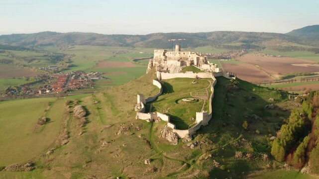 Aerial view pf Spis castle ruins in eastern Slovakia with warm light over the fortress and mountains in the background