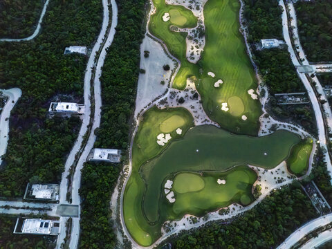 Aerial view of Provincia Golf Club with lush green fairways, sand bunkers, and water hazards surrounded by tropical vegetation and modern homes, Merida, Yucatan, Mexico.