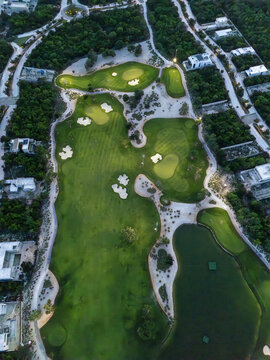 Aerial view of Provincia Golf Club featuring lush green fairways, sand bunkers, and water hazards surrounded by residential areas in Merida, Yucatan, Mexico.