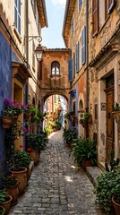 Fototapeta premium Sunlit narrow cobblestone street in a historic European village featuring colorful facades and lush potted plants