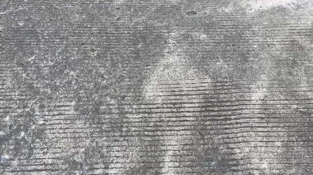 Texture of brushed concrete surface with grooved pattern