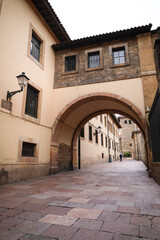 Fototapeta premium Narrow street with stone arch next to The Cathedral of San Salvador in Oviedo city, Asturias