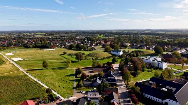 Aerial drone view of Jelling Church, Viking burial mounds, and surrounding town within UNESCO heritage landscape in Denmark