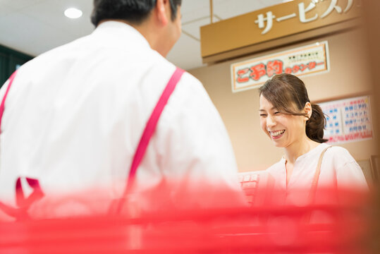 スーパーマーケットのレジで買い物をする40代女性