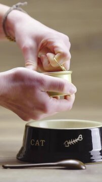 Hands opening a can of wet food for cat