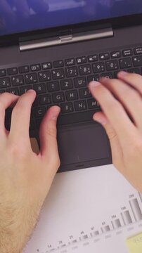 Busy person typing on laptop at work top view