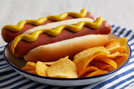 Homemade Hot Dog with Potato Chips on a Plate, low angle view. Close-up.