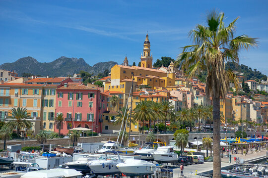 Yachts in Menton harbor with mountains in the background