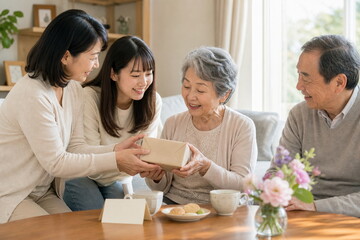 祖母へ贈り物を手渡す敬老の日の三世代家族