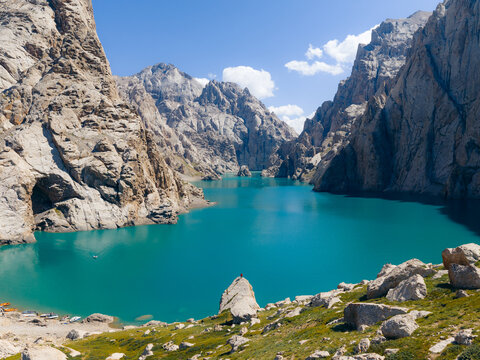 Aerial view of the turquoise waters of Kol-Suu lake nestled between steep limestone cliffs and rugged mountain peaks in At-Bashi District, Naryn Region, Kyrgyzstan.