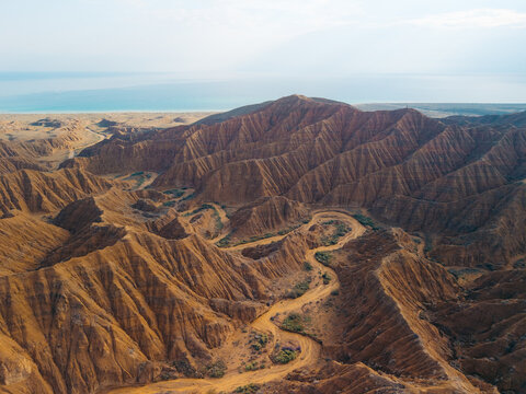 Aerial view of Ak Say Canyon and Valley of Forgotten Rivers with dramatic eroded red rock formations and winding paths near Issyk-Kul lake Ak Say, Issyk-Kul Region, Kyrgyzstan.