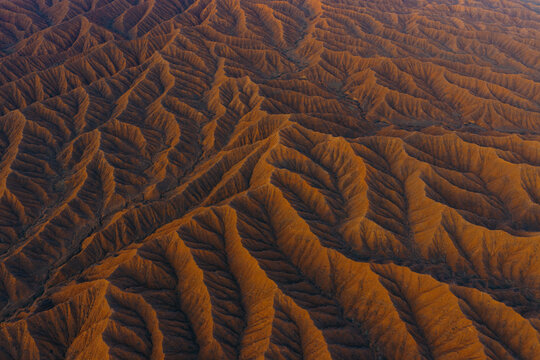Aerial view of the intricate eroded orange sandstone ridges and deep valleys of Ak Say Canyon, the Valley of Forgotten Rivers, in Ak Say, Issyk-Kul Region, Kyrgyzstan.