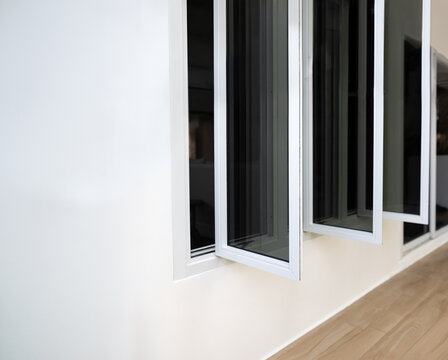 Three panel aluminium casement window stay on white wall.
