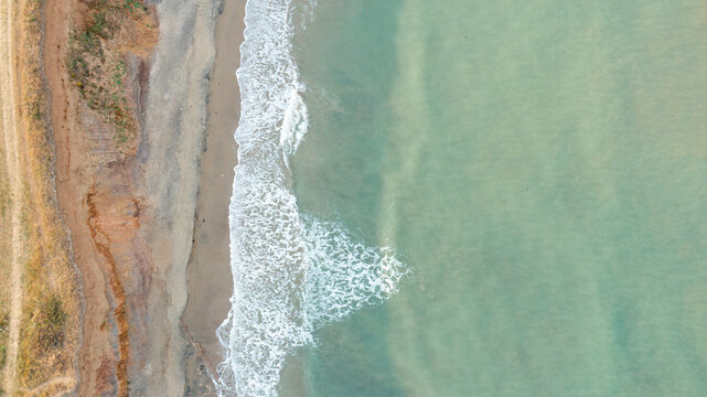 Aerial view of the turquoise waters and sandy shoreline of Compton Bay with coastal cliffs, Newport, Isle of Wight, United Kingdom.