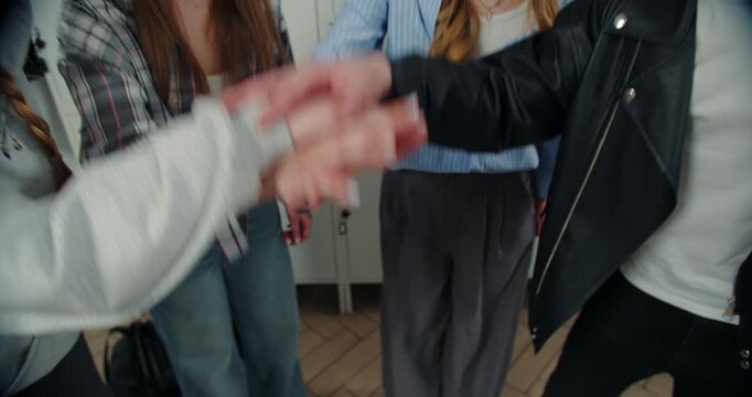 Students joining hands for team unity