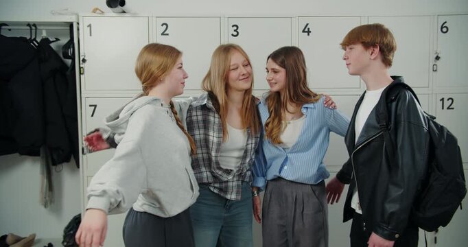 Teenage friends hugging together by school lockers