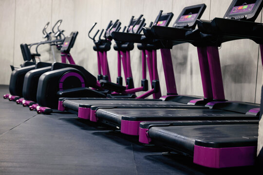 Gym cardio zone with exercise bikes and treadmills, selective focus