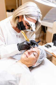 Aesthetician performs eyebrow permanent makeup procedure