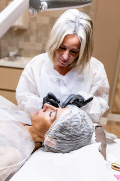 Esthetician doing permanent makeup on a woman's eyebrow