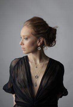 Elegant woman in profile wearing layered necklaces