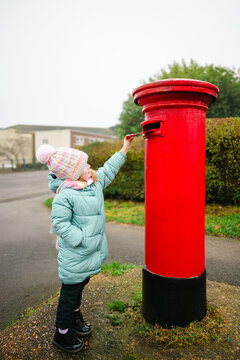 Little girl mailing red letter to Santa on Christmas Holiday