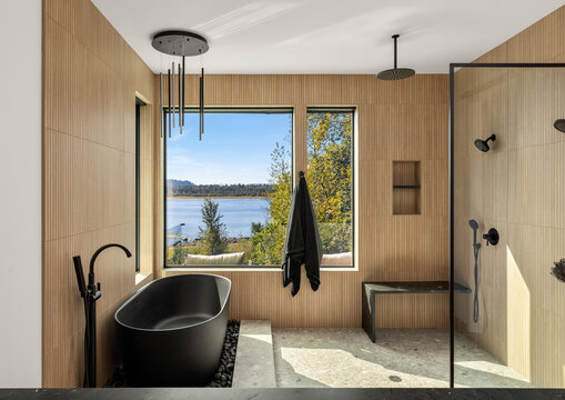 Luxurious bathroom with soaking tub, walk in shower and water view