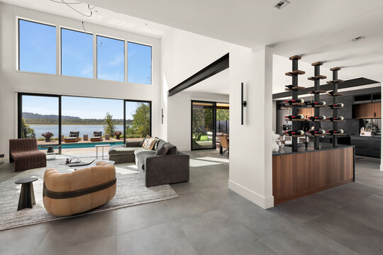 Spacious modern living room and kitchen with a pool and river view