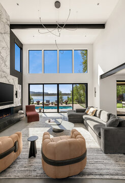 Stunning modern living room with high ceilings and pool and river view