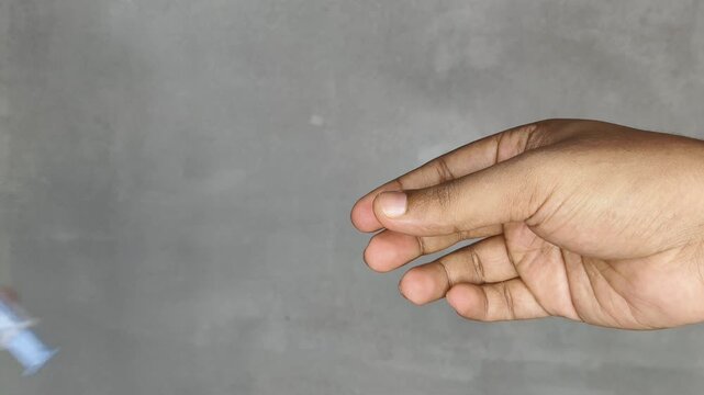 Closeup of drug addict person hand sharing used dirty syringe. Cocaine, heroin and morphine addiction unhygienic habit spreading HIV or hepatitis disease concept. Consuming narcotic substance concept.
