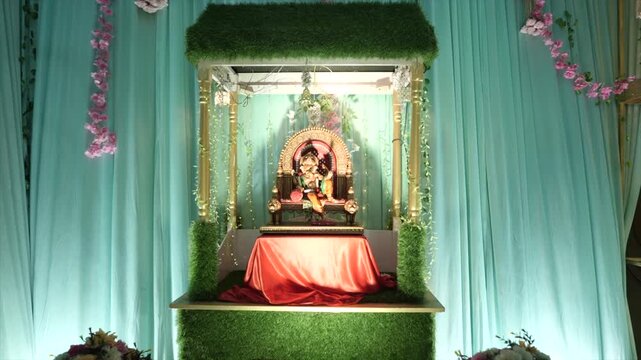 Dynamic angle of a golden Lord Ganesha statue resting on an ornate wedding mandap, radiating divine blessings, prosperity, elegance, and spiritual significance.