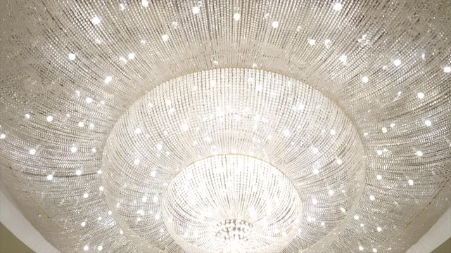 Elegant close-up view of a sparkling crystal chandelier hanging from the ceiling, reflecting brilliant light and adding luxury, sophistication, and timeless beauty to the interior.