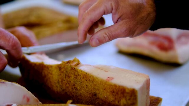 market pork lard. Stack of thick sliced cured pork belly with visible fat layers and rind texture arranged for sale as traditional spanish food product in local market setting