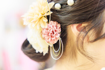 Naklejka premium 華やかな造花の髪飾りをあしらった着物姿の女性のヘアスタイル（後ろ姿）