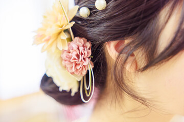 Naklejka premium 華やかな造花の髪飾りをあしらった着物姿の女性のヘアスタイル（後ろ姿）
