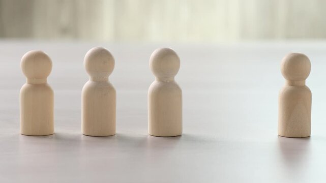 Woman taking black figure among wooden ones at light table, closeup