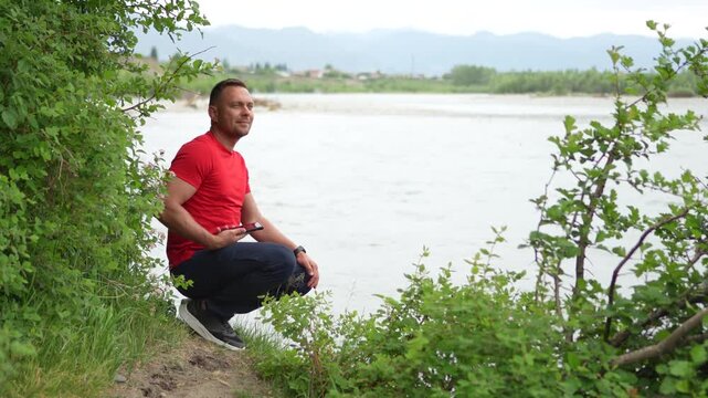 A man is traveling in the Altai Mountains. He enjoys the views of the Katun River and takes a photo of the confluence of the two rivers. The confluence of the Chuya and Katun rivers.