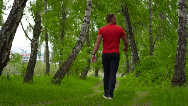 A man travels through the Altai Mountains. A man walks through a mixed forest in Siberia. A male traveler walks through a forest during a mountain trip.